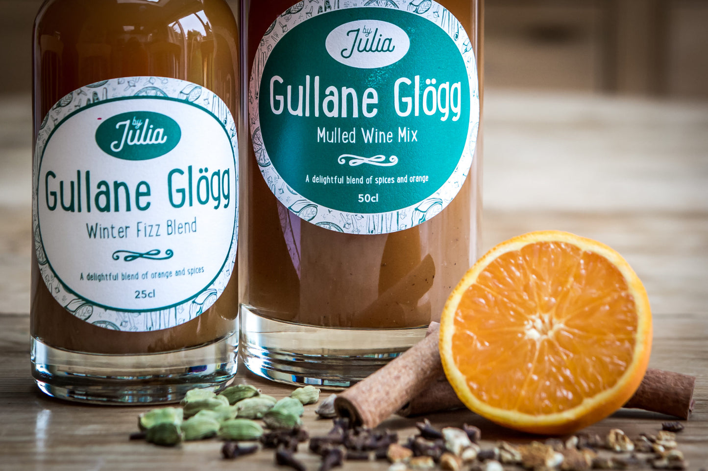 Gullane Glögg Mulled Wine Mix and Winter Fizz Blend bottles in close up with orange and cinnamon sticks